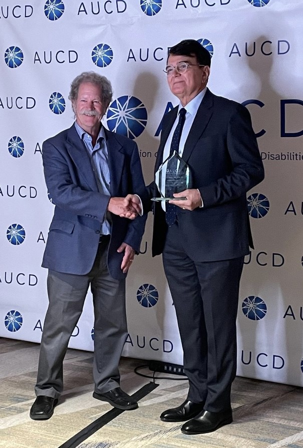 David Helm presenting award to Kerim Munir at AUCD conference